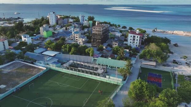 Aerial view of the football pitch and coastal buildings in Gulhi Maldives. Aerial view of the football pitch and coastal buildings in Gulhi Maldives.
