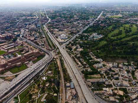 Aerial view of Bala Hisar Fort surrounded by historic walls urban roads and green spaces in Peshawar Khyber Pakhtunkhwa Pakistan.