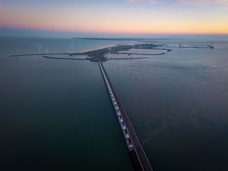 Aerial view of the Oosterscheldekering storm surge barrier and offshore wind turbines at twilight in the Netherlands.