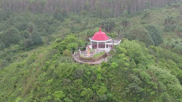 Aerial view of Grand Bassin temple on a green hill Mauritius.