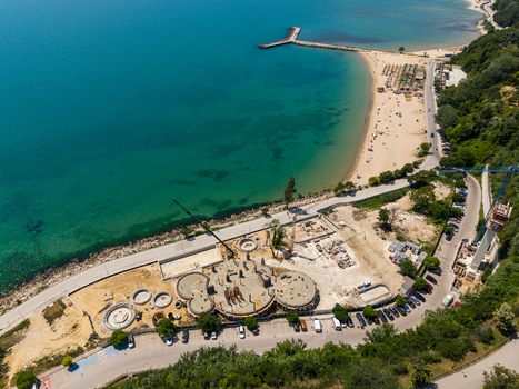 Aerial view of the construction site at Alley First featuring circular building foundations construction equipment and a nearby beach in Varna Varna Bulgaria. Aerial view of the construction site at Alley First featuring circular building foundations construction equipment and a nearby beach in Varna Varna Bulgaria.