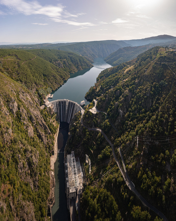 Aerial view of the Santo Estevo Dam nestled in a deep canyon with lush green hills and a winding river in Ourense Ourense Spain. Aerial view of the Santo Estevo Dam nestled in a deep canyon with lush green hills and a winding river in Ourense Ourense Spain.