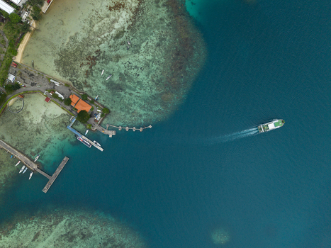 Aerial view of turquoise waters stretching along the coast near the Karimunjawa ferry port where boats are anchored and ferries can be seen departing Karimunjawa Indonesia. Aerial view of turquoise waters stretching along the coast near the Karimunjawa ferry port where boats are anchored and ferries can be seen departing Karimunjawa Indonesia.
