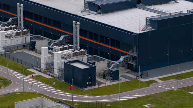 Aerial view of the Agriport data center facility featuring modern industrial architecture with cooling units and chimneys in Middenmeer Noord Holland Netherlands. Aerial view of the Agriport data center facility featuring modern industrial architecture with cooling units and chimneys in Middenmeer Noord Holland Netherlands.