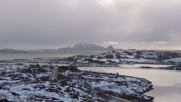 Aerial view of snowy Lofoten mountains and icy coastline Norway.