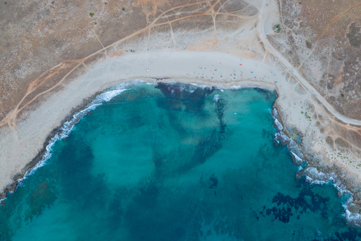 Aerial view of the turquoise waters and rocky coastline of Riserva Naturale Orientata dello Zingaro with sandy beach and dirt paths in San Vito Lo Capo Sicilia Italy. Aerial view of the turquoise waters and rocky coastline of Riserva Naturale Orientata dello Zingaro with sandy beach and dirt paths in San Vito Lo Capo Sicilia Italy.