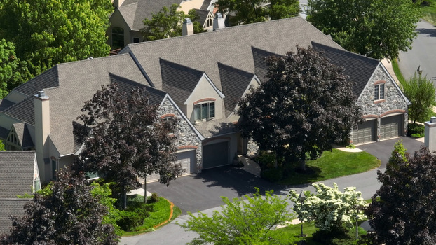 Aerial view of a retirement community campus in West Lampeter Township with stone and stucco buildings shingled roofs and lush trees in Willow Street Pennsylvania United States.