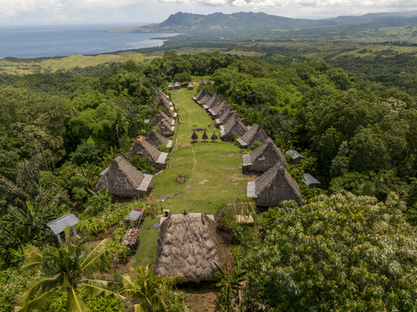 Aerial view of Kampung Adat Belaraghi a traditional village with thatched roof houses on a lush green hilltop overlooking the sea in Kecamatan Aimere Nusa Tenggara Timur Indonesia. Aerial view of Kampung Adat Belaraghi a traditional village with thatched roof houses on a lush green hilltop overlooking the sea in Kecamatan Aimere Nusa Tenggara Timur Indonesia.