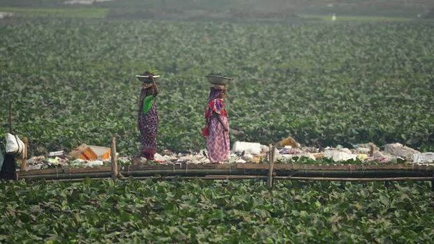 View of women carrying baskets on heads in Bogura Bangladesh.
