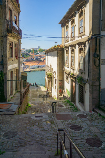 Porto Portugal 13 July 2021 View of the old city streets leading down towards the Douro River where sun kissed buildings meet the shimmering water. Porto Portugal 13 July 2021 View of the old city streets leading down towards the Douro River where sun kissed buildings meet the shimmering water.