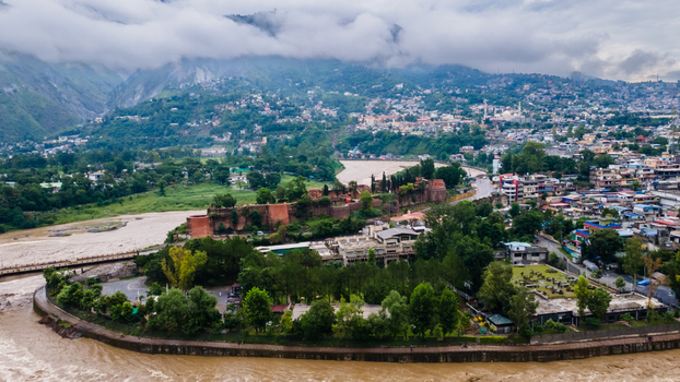 Aerial view of the historic Red Fort surrounded by lush trees and the winding river with the city and cloudy mountains in the background Muzaffarabad Azad Kashmir Pakistan. Aerial view of the historic Red Fort surrounded by lush trees and the winding river with the city and cloudy mountains in the background Muzaffarabad Azad Kashmir Pakistan.