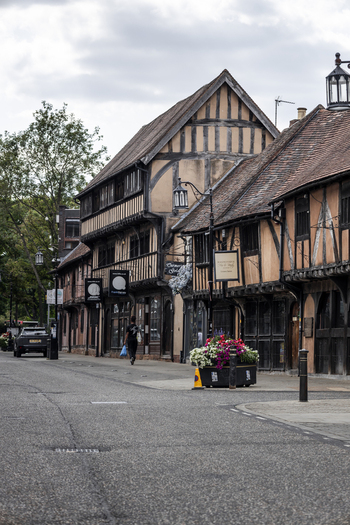Coventry England United Kingdom 20 July 2026 View of historic timber framed buildings on Spon Street with a person walking along the sidewalk under a cloudy sky.