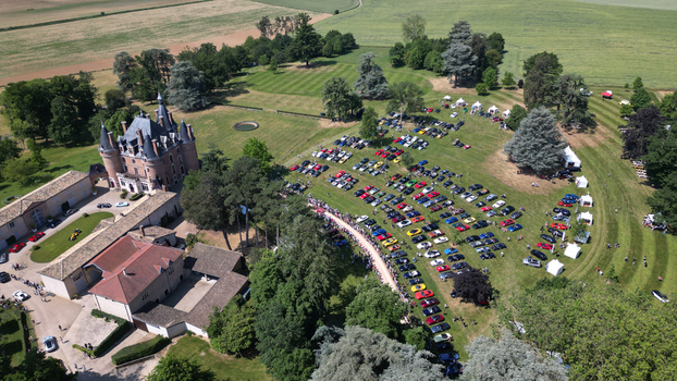 Francheleins France 04 June 2023 Aerial view of Chateau de Vataneins with a large exhibition of colorful cars on the green lawn surrounded by lush trees and agricultural fields. Francheleins France 04 June 2023 Aerial view of Chateau de Vataneins with a large exhibition of colorful cars on the green lawn surrounded by lush trees and agricultural fields.