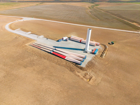 Aerial view of wind turbine components including a tower section and blades at a construction site in a rural landscape Swellendam Western Cape South Africa. Aerial view of wind turbine components including a tower section and blades at a construction site in a rural landscape Swellendam Western Cape South Africa.