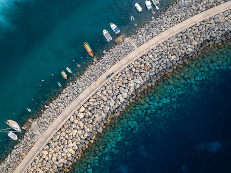 Aerial view of boats moored along the rugged stone pier contrasting with the turquoise and deep blue waters of Mgarr Harbour Mgarr Harbour Gozo Malta. Aerial view of boats moored along the rugged stone pier contrasting with the turquoise and deep blue waters of Mgarr Harbour Mgarr Harbour Gozo Malta.