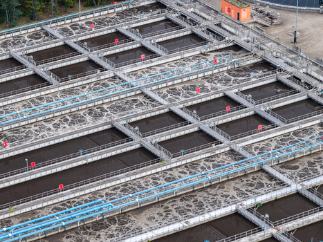 Aerial view of Klarwerk Ruhleben sewage treatment plant with aeration tanks bubbling water industrial metal walkways and blue pipes in Berlin Berlin Germany.
