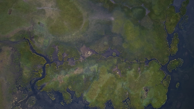 Aerial view of Song Kul lake with lush green wetlands and winding water channels in Naryn Region Kyrgyzstan. Aerial view of Song Kul lake with lush green wetlands and winding water channels in Naryn Region Kyrgyzstan.