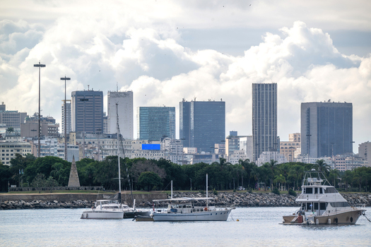 View of boats moored in the harbor with the modern skyline of the Centro district under a cloudy sky in Rio de Janeiro State of Rio de Janeiro Brazil.