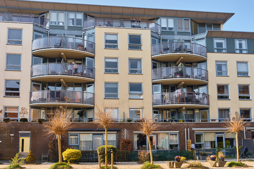 Wormerveer Netherlands 22 March 2026 View of De Zaanstroom senior apartment building featuring modern architecture with curved glass balconies and pollarded trees in the foreground. Wormerveer Netherlands 22 March 2026 View of De Zaanstroom senior apartment building featuring modern architecture with curved glass balconies and pollarded trees in the foreground.