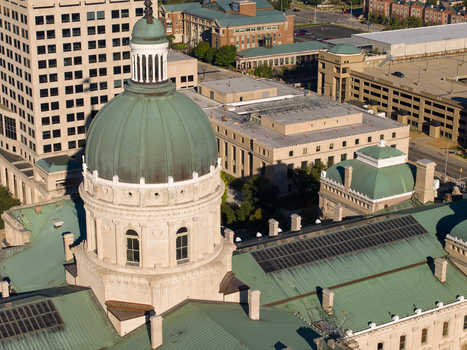 Aerial view of the Indiana State Capitol dome with its green copper roof surrounded by urban buildings and city streets in Indianapolis Indiana United States. Aerial view of the Indiana State Capitol dome with its green copper roof surrounded by urban buildings and city streets in Indianapolis Indiana United States.