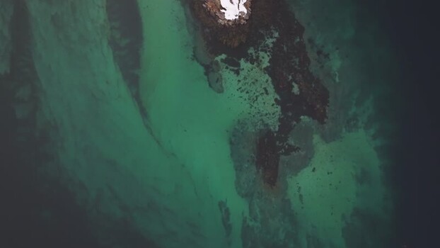 Aerial view of turquoise waters and rocky coast in Lofoten Norway.