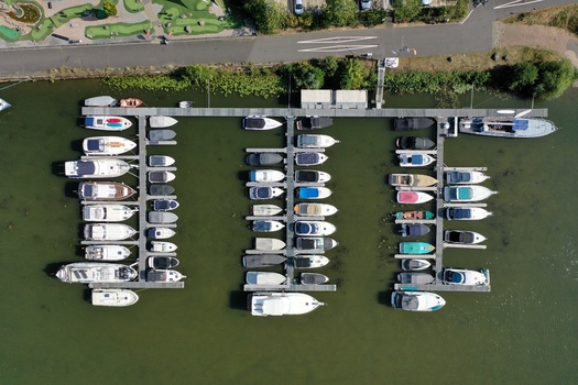 Aerial view of the Aschaffenburger Bootsclub with numerous motorboats and yachts docked at wooden piers on calm green water in Aschaffenburg Bayern Germany.