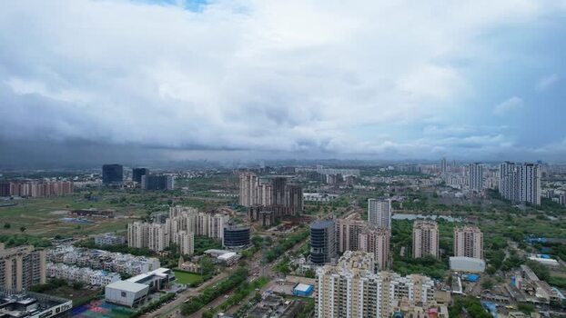 Aerial view of Gurugram skyscrapers and green fields India.
