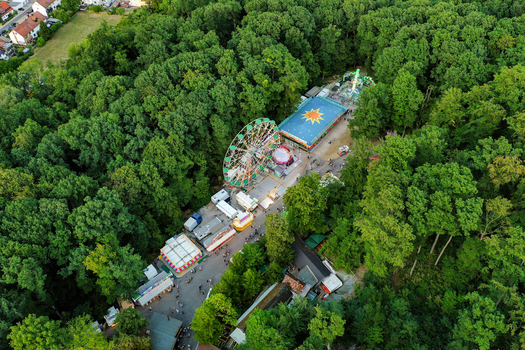 Forchheim Germany 25 July 2025 Aerial view of the Annafest fairground with its Ferris wheel and colorful stalls nestled within the dense green trees of the Kellerwald forest. Forchheim Germany 25 July 2025 Aerial view of the Annafest fairground with its Ferris wheel and colorful stalls nestled within the dense green trees of the Kellerwald forest.