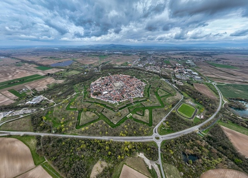 Aerial view of the star shaped fortress city surrounded by vibrant green moats and earthworks under a dramatic sky Neuf Brisach Grand Est France.