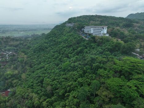 Aerial view of a hotel nestled on a lush green hillside overlooking the surrounding landscape in Yogyakarta Special Region of Yogyakarta Indonesia. Aerial view of a hotel nestled on a lush green hillside overlooking the surrounding landscape in Yogyakarta Special Region of Yogyakarta Indonesia.