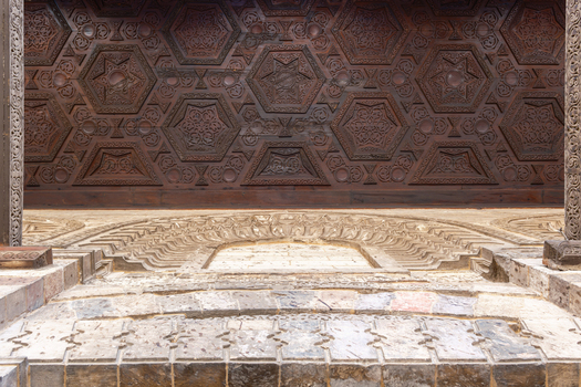 View of the intricate geometric wood carvings and detailed stone masonry at the historic Mosque of al Salih Tala i Cairo Egypt. View of the intricate geometric wood carvings and detailed stone masonry at the historic Mosque of al Salih Tala i Cairo Egypt.
