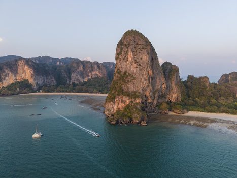 Aerial view of towering limestone cliffs meet the turquoise waters of Railay Beach Krabi Thailand.