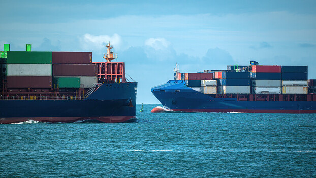 View of two large cargo container ships navigating the blue waters under a cloudy sky Lisbon Lisbon Portugal. View of two large cargo container ships navigating the blue waters under a cloudy sky Lisbon Lisbon Portugal.