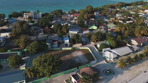 Aerial view of a coastal village with palm trees and houses Maldives. Aerial view of a coastal village with palm trees and houses Maldives.