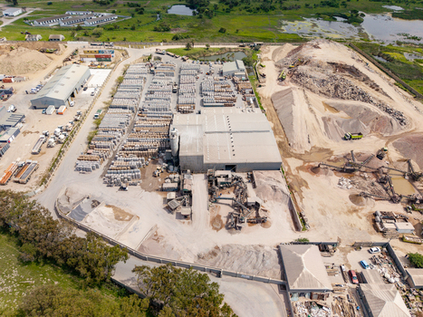 Aerial view of the Philippi industrial site featuring large stockpiles of gravel rows of stacked concrete products and warehouse buildings in Cape Town Western Cape South Africa.