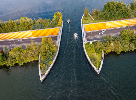 Aerial view of Aquaduct Veluwemeer showing boats passing over the highway with cars driving through the water tunnel in Harderwijk Gelderland Netherlands.