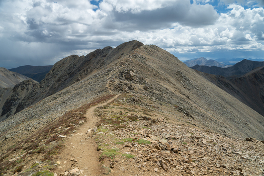 View of Mount Missouri in the Collegiate Peaks Wilderness featuring a rugged mountain trail winding through rocky alpine terrain under a cloudy sky in Buena Vista Colorado United States.