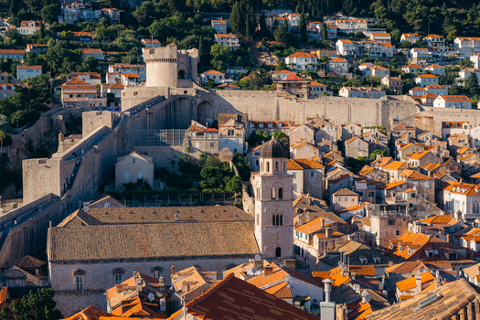 View of Dubrovnik Old Town featuring historic stone walls Minceta Tower and the Franciscan Monastery bell tower among rooftops in Dubrovnik Dubrovnik Neretva County Croatia. View of Dubrovnik Old Town featuring historic stone walls Minceta Tower and the Franciscan Monastery bell tower among rooftops in Dubrovnik Dubrovnik Neretva County Croatia.