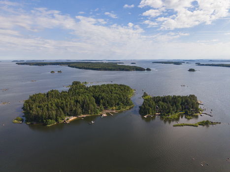 Aerial view of forested islands in the Gulf of Finland with small wooden docks and boats moored along the shore near Hamina Kymenlaakso Finland. Aerial view of forested islands in the Gulf of Finland with small wooden docks and boats moored along the shore near Hamina Kymenlaakso Finland.