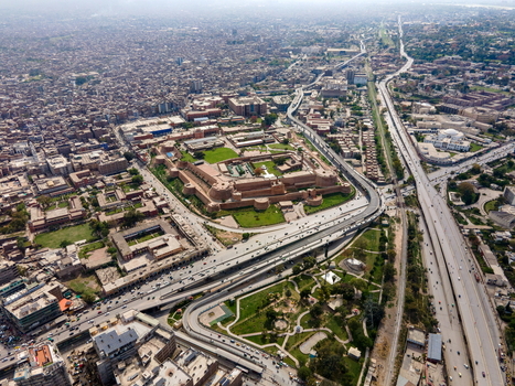 Aerial view of the historic Bala Hisar Fort surrounded by dense urban buildings major roads and green spaces in Peshawar Khyber Pakhtunkhwa Pakistan.