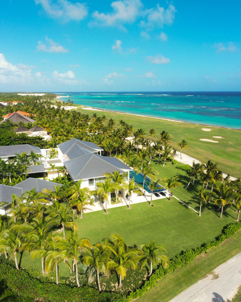 Aerial view of La Cana Golf Club featuring a luxury villa with a pool palm trees and manicured lawns overlooking the Caribbean Sea Punta Cana La Altagracia Dominican Republic. Aerial view of La Cana Golf Club featuring a luxury villa with a pool palm trees and manicured lawns overlooking the Caribbean Sea Punta Cana La Altagracia Dominican Republic.
