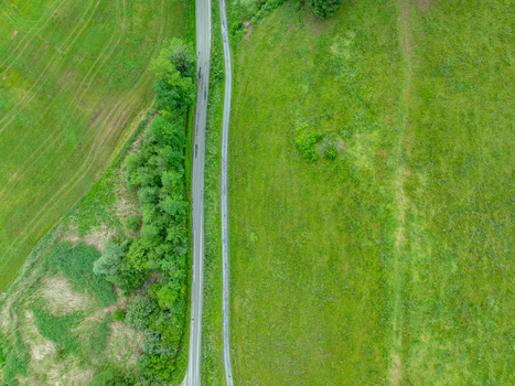 Aerial view of a road winding through lush green meadows and trees in Nationalpark Gesause Admont Steiermark Austria.
