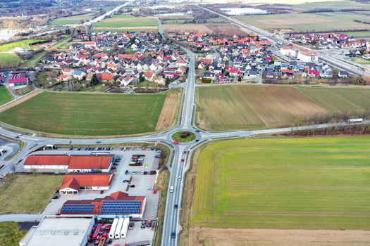 Aerial view of a roundabout connecting roads between residential areas and green agricultural fields in Forchheim Bavaria Germany. Aerial view of a roundabout connecting roads between residential areas and green agricultural fields in Forchheim Bavaria Germany.