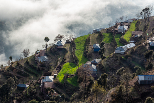 View of houses dotting the terraced green hillside under a soft blanket of clouds a serene landscape Pir Chanasi Azad Kashmir Pakistan. View of houses dotting the terraced green hillside under a soft blanket of clouds a serene landscape Pir Chanasi Azad Kashmir Pakistan.