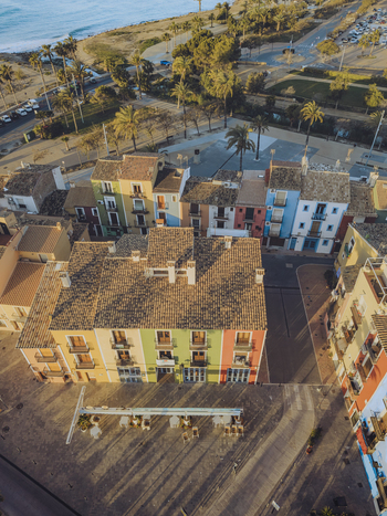 Aerial view of colorful traditional houses and a town square with palm trees near the Mediterranean coast in La Vila Joiosa Valencian Community Spain. Aerial view of colorful traditional houses and a town square with palm trees near the Mediterranean coast in La Vila Joiosa Valencian Community Spain.