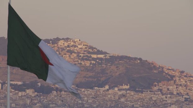 Aerial view of Algerian flag over hillside city Algeria.