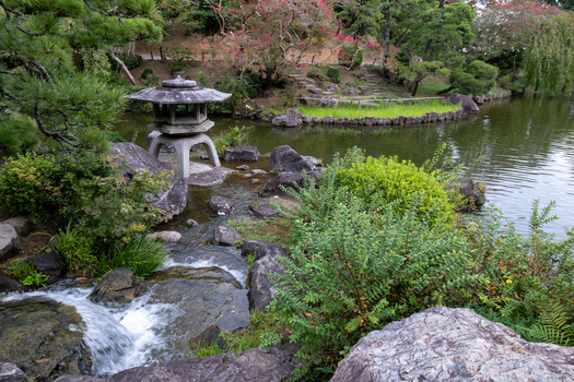 View of a serene Japanese garden with a stone lantern flowing water and vibrant greenery reflecting on the tranquil pond s surface Narita Chiba Japan. View of a serene Japanese garden with a stone lantern flowing water and vibrant greenery reflecting on the tranquil pond s surface Narita Chiba Japan.