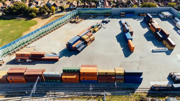Indjija Serbia 24 August 2026 Aerial view of a container yard with rows of stacked shipping containers railway tracks and a perimeter fence in the industrial area.