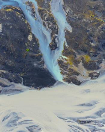 Aerial view of a glacial river with braided channels dark volcanic sand and turquoise glacial water flowing through the landscape in Selfoss Sveitarfelagid Arborg Iceland. Aerial view of a glacial river with braided channels dark volcanic sand and turquoise glacial water flowing through the landscape in Selfoss Sveitarfelagid Arborg Iceland.