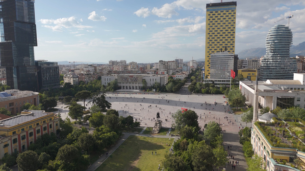 Aerial view of Skanderbeg Square in Tirane featuring the Skanderbeg monument surrounded by modern skyscrapers historic buildings and lush green trees in Tirane Qarku i Tiranes Albania.